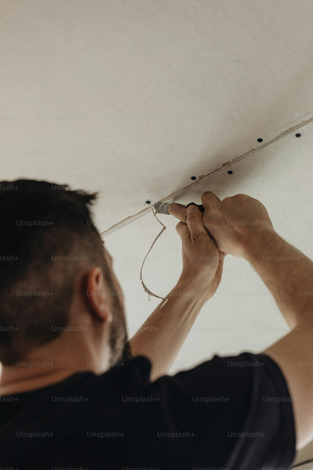 um homem está consertando uma luminária em uma sala