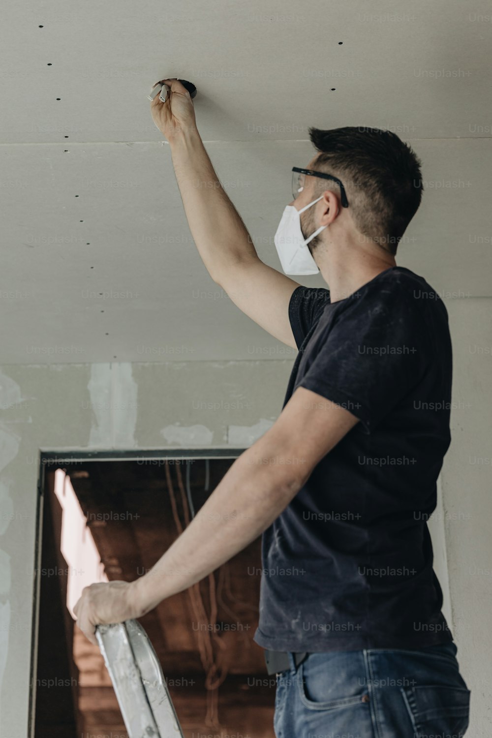 Un hombre con una máscara facial pintando una pared