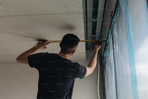 a man working on a ceiling in a room
