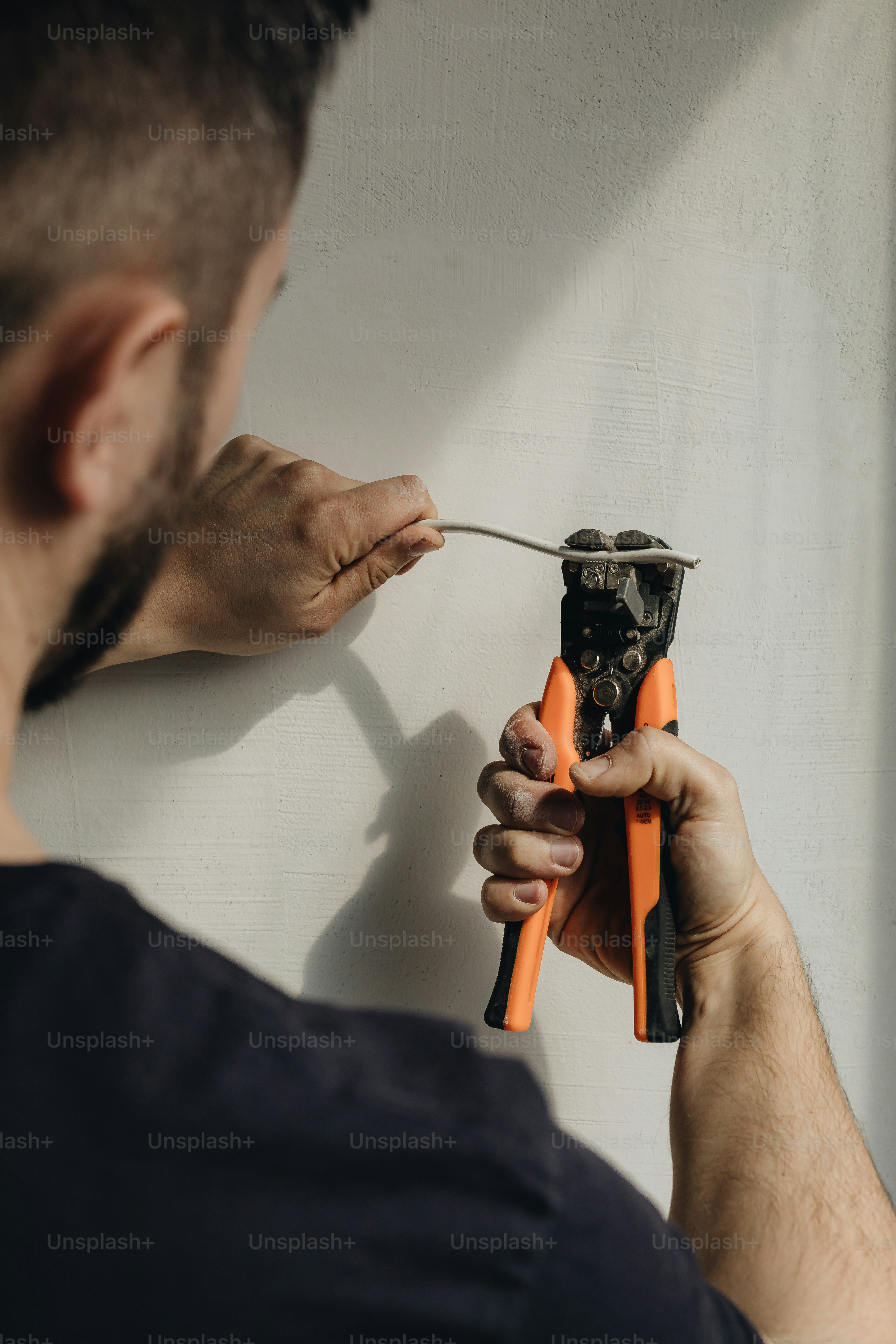 a man holding a pair of pliers in his hands