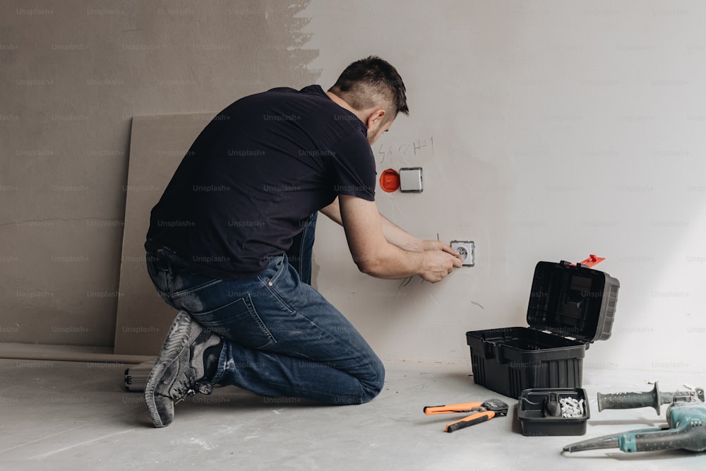 a man working on a wall with tools