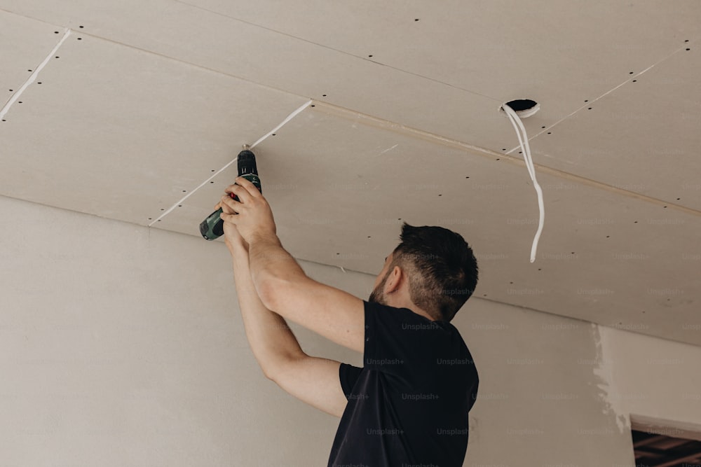 a man working on a ceiling with a pair of shoes