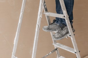 a person standing on a ladder with a pair of shoes on it