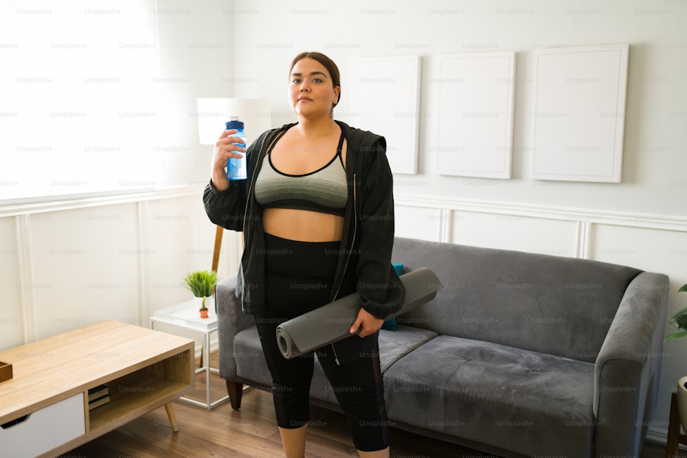 Donna motivata con obesità che si prepara per il suo allenamento quotidiano
