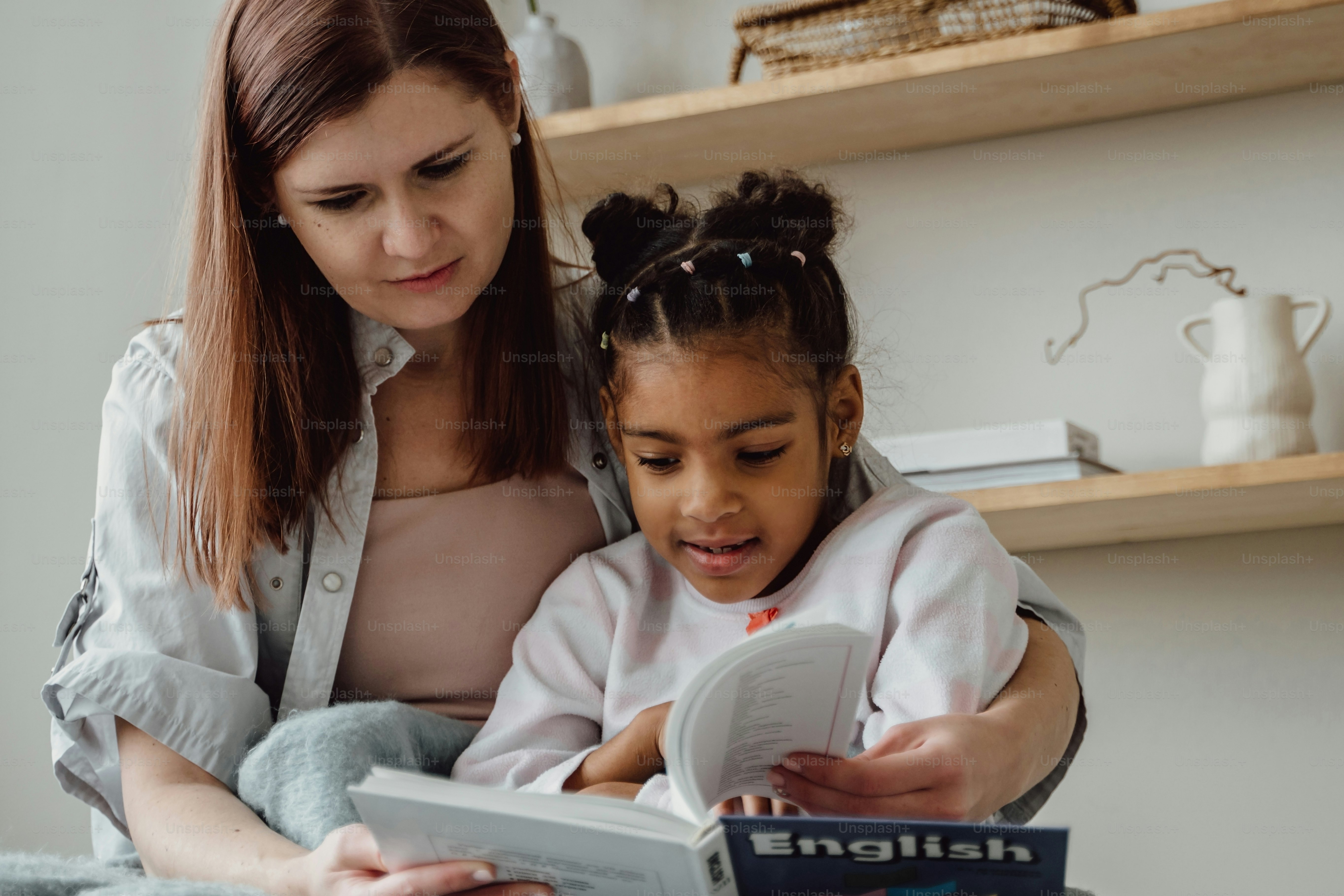 a woman reading a book to a little girl