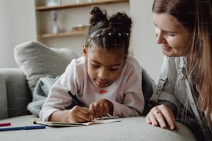 a woman and a little girl sitting on a couch