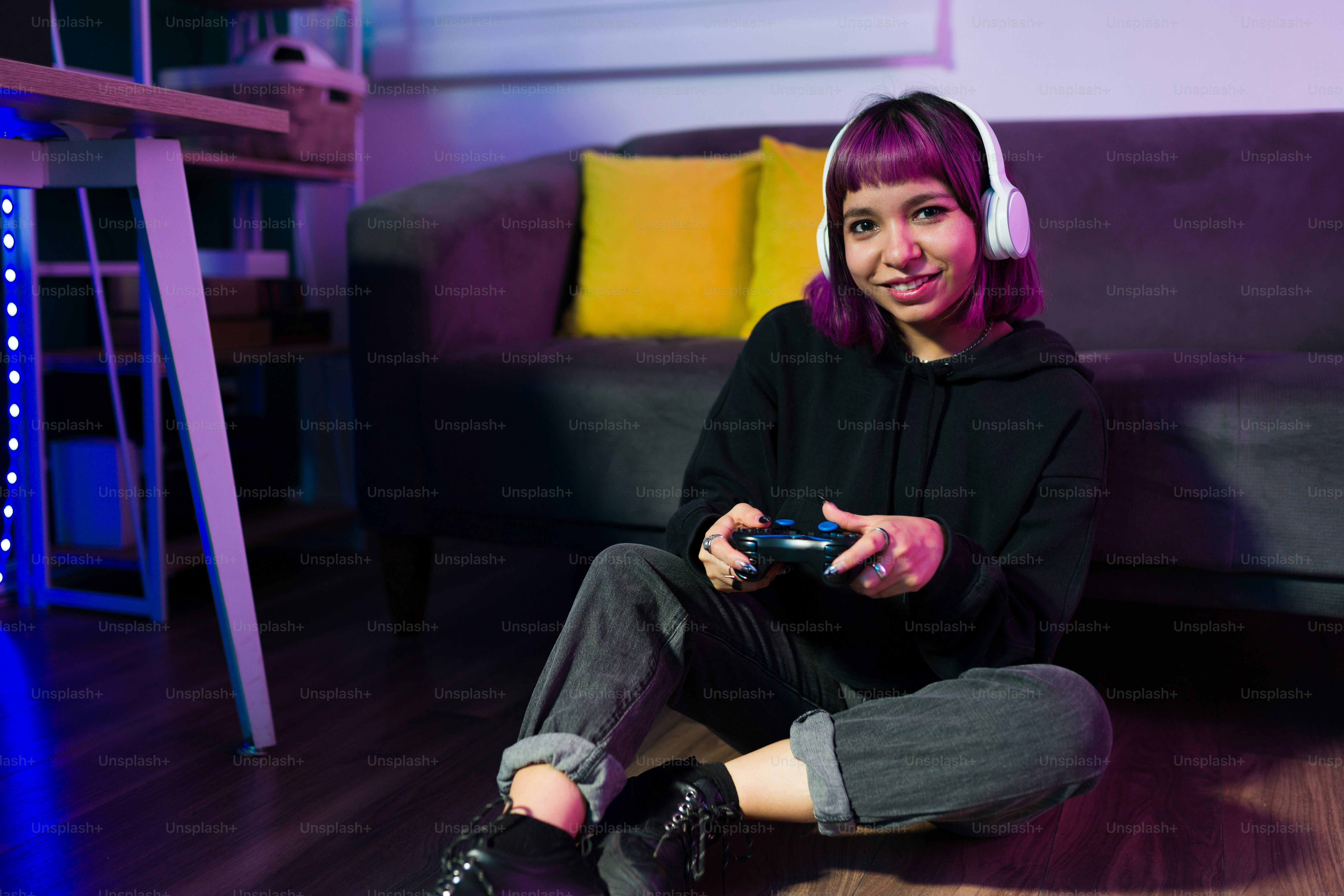Feliz jugador relajado mirando a la cámara y sonriendo mientras juega videojuegos en casa
