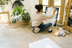 Feeling inspired. Hispanic young painter practicing oil painting technique on a blank canvas