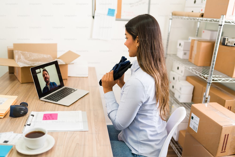 Trying to get a good deal from my supplier. Latin business owner talking on an online video call with a vendor about buying new products for her clothing shop