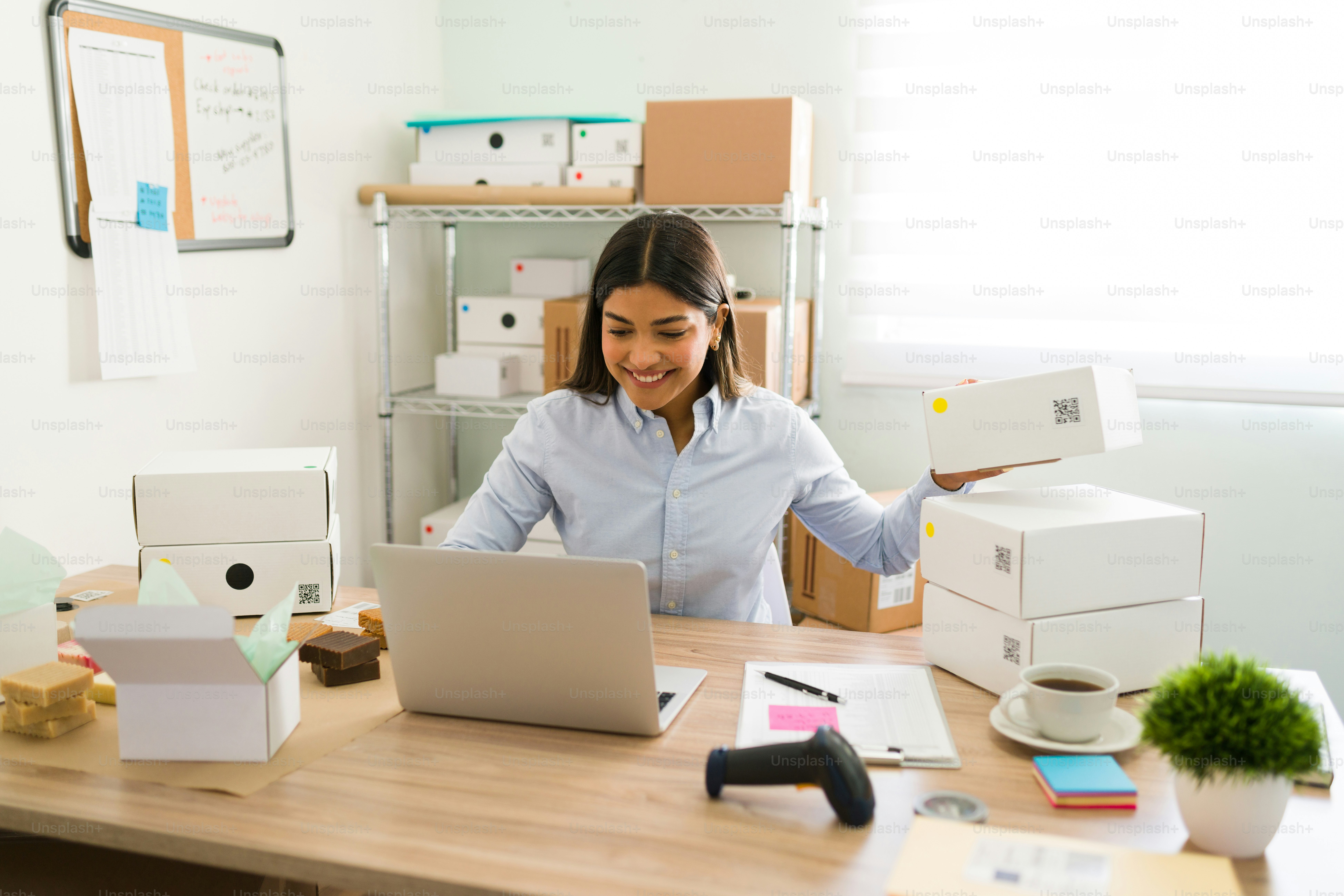 Female business owner smiling and feeling happy while preparing packages to ship to customers. Young woman with a lot of online orders