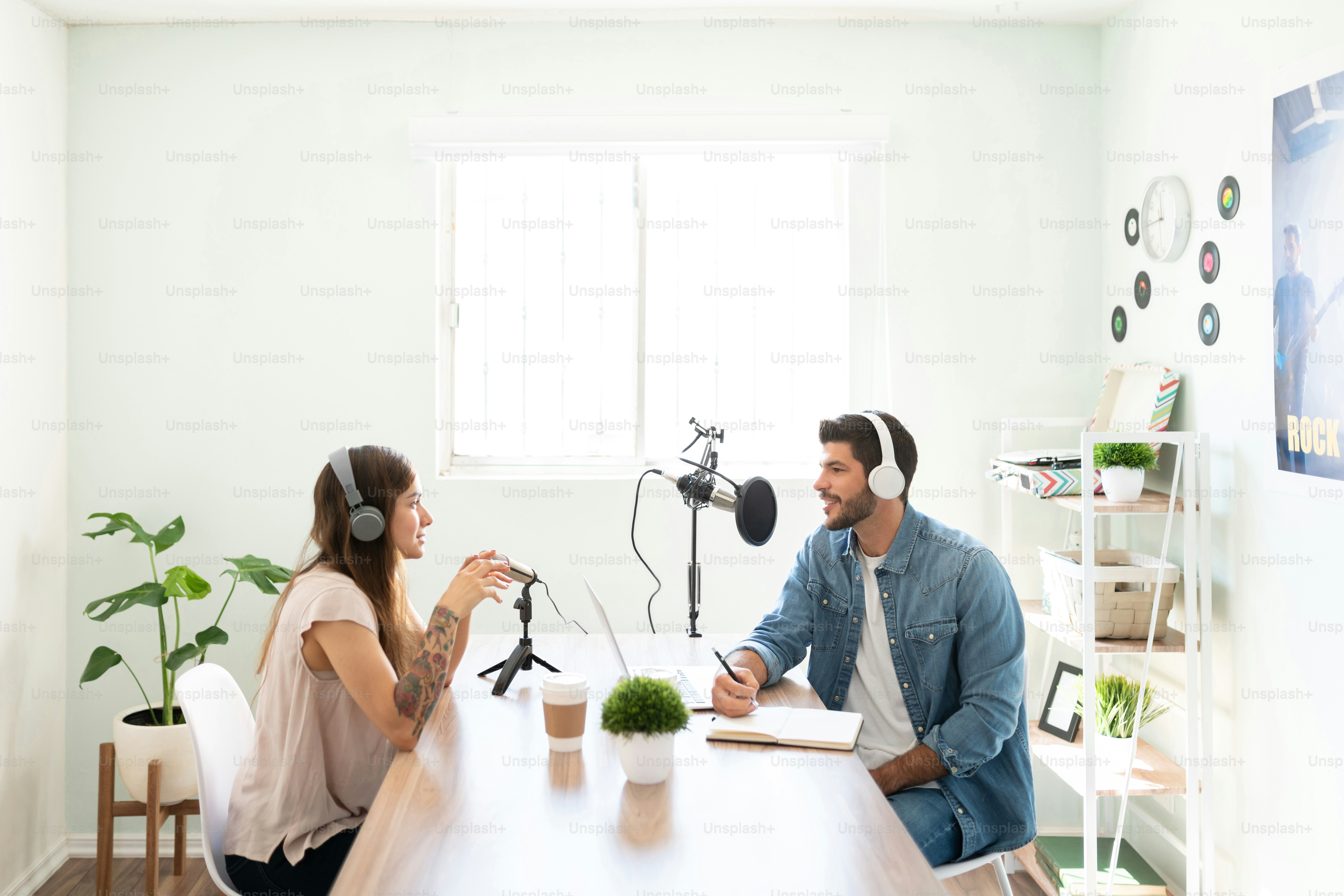 Profile view of a male broadcaster and an invited artist going through some questions during an interview in a radio show