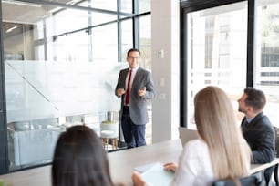 Young businessman giving a presentation to coworkers in a meeting room