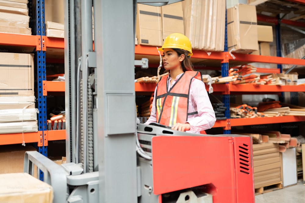 Confident female supervisor operating forklift by rack at factory