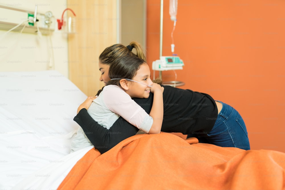 Mother embracing daughter and meeting her after surgery in a hospital room
