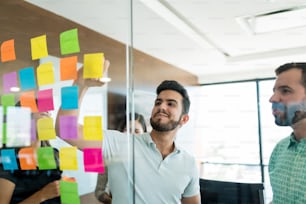 Junger Geschäftsmann beim Brainstorming mit Kollegen in einem Meeting im Büro