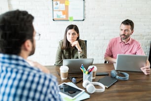 Male executive giving presentation to young coworkers in board room at office