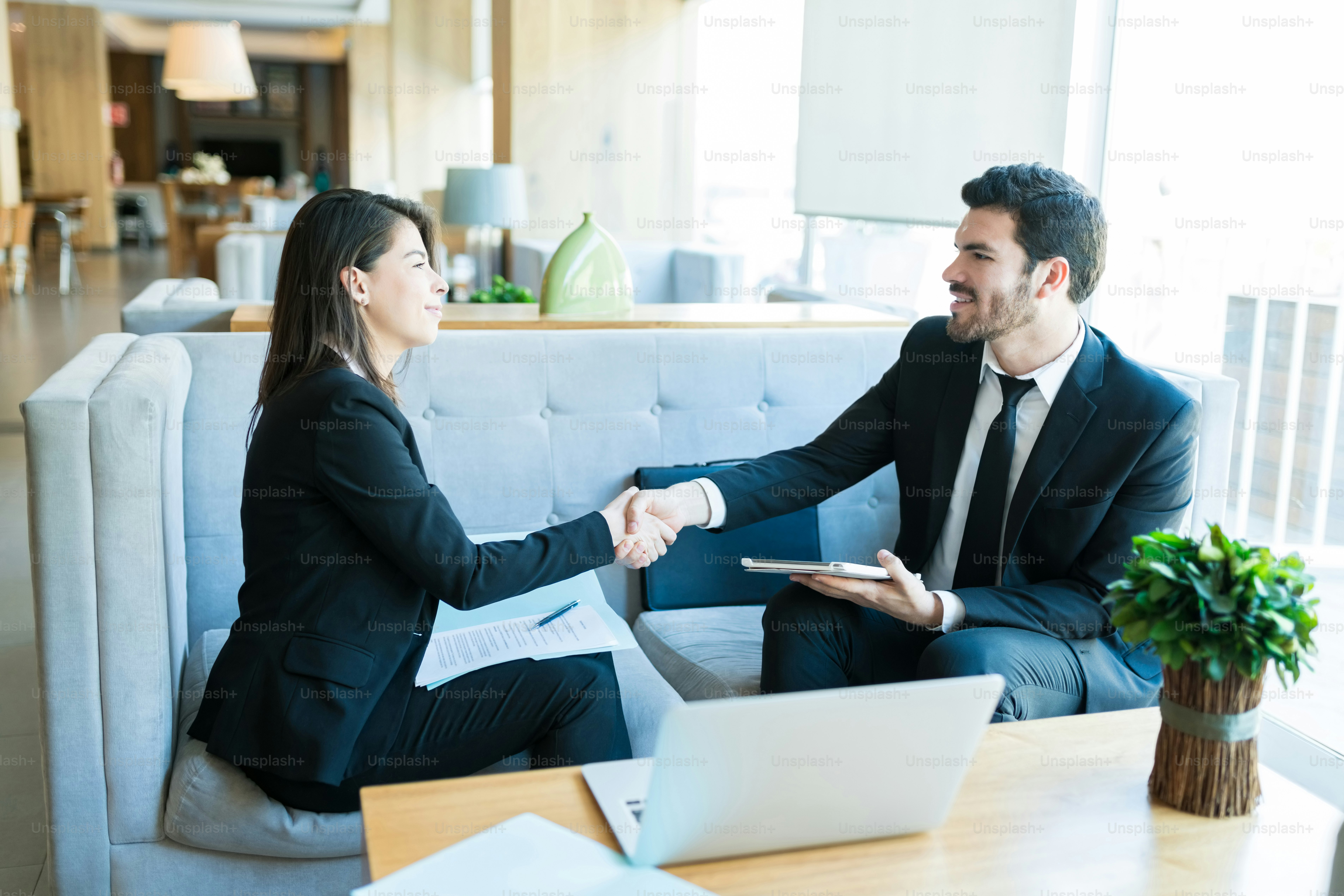 Smiling business professionals congratulating with handshake during ...