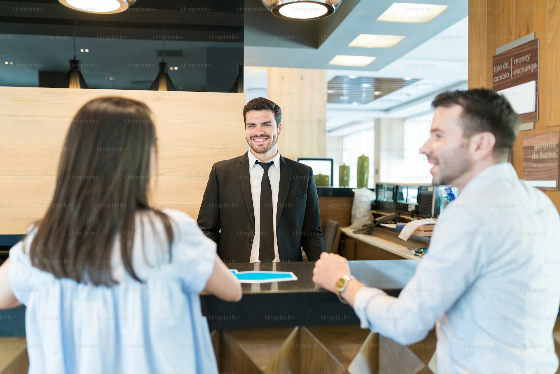 Hotel manager warmly welcoming guests at the reception