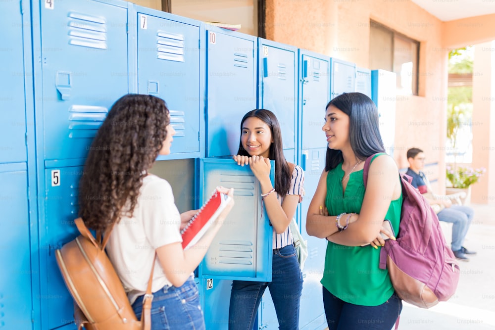 Teenage girls talking while standing in hallway at university