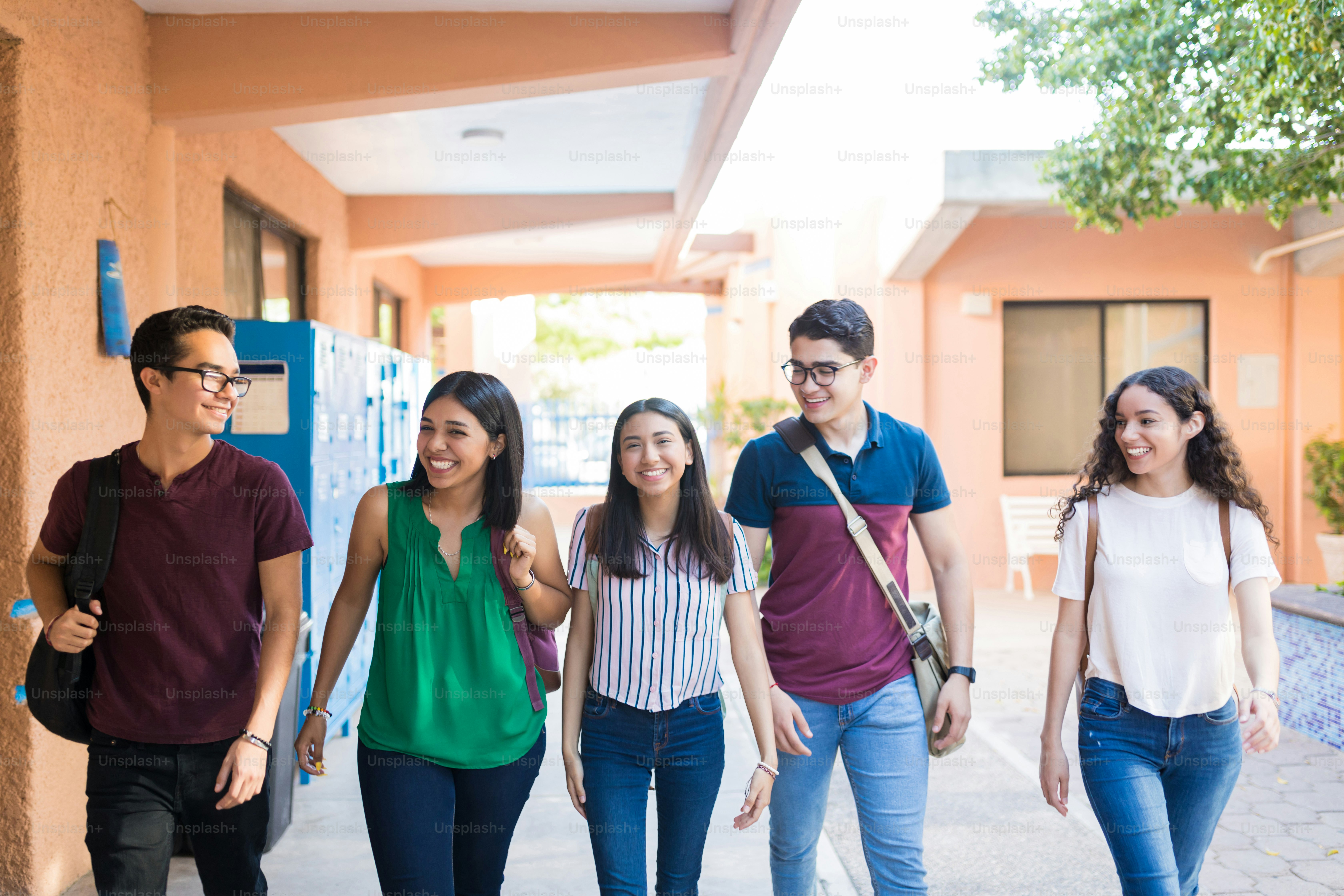 Group of teenage friends walking together in corridor at university