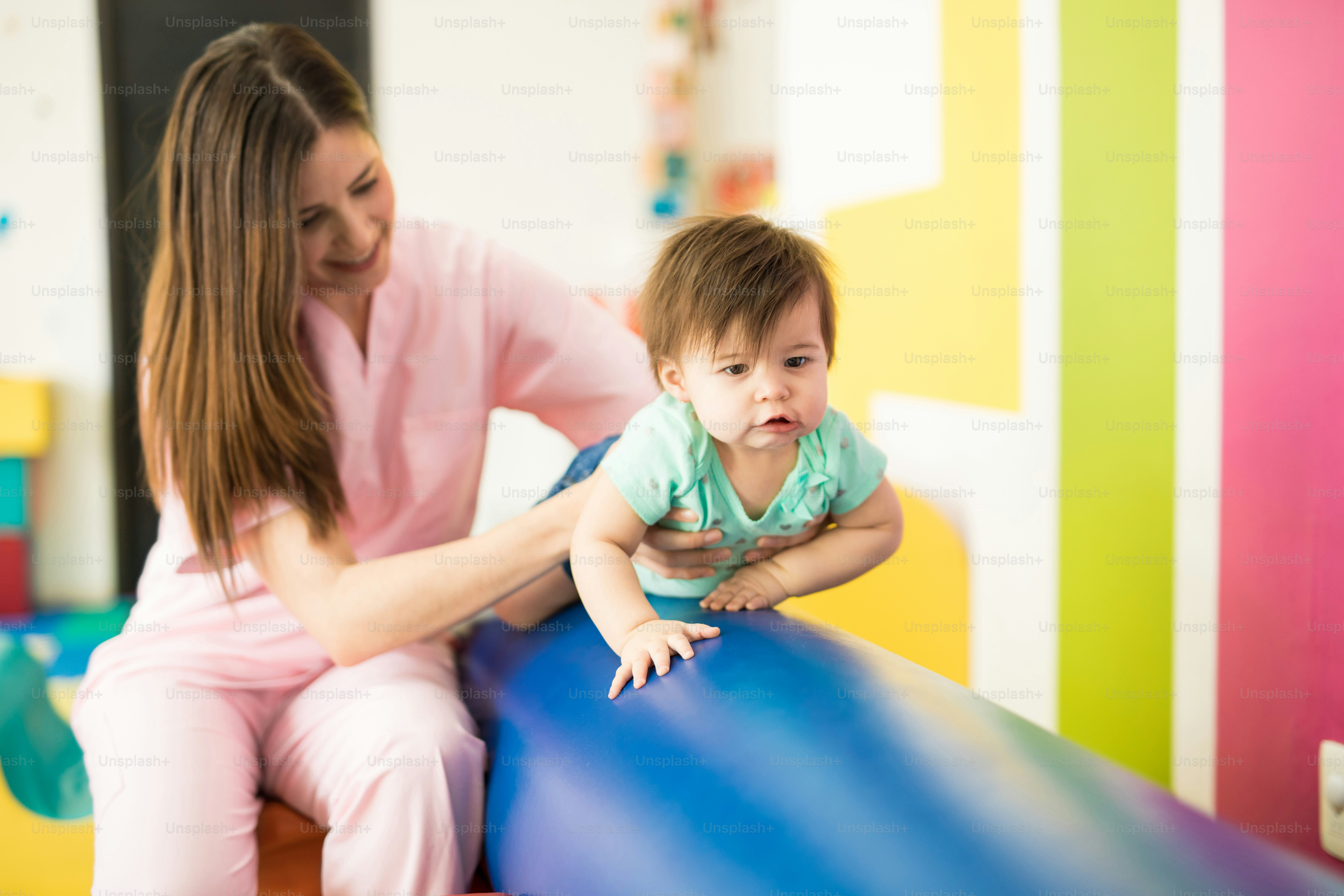 Cute baby working on her balance while crawling on a beam in an early stimulation and development school