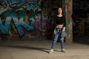 Ganzkörperporträt einer schönen Hip-Hop-Tänzerin, die sich darauf vorbereitet, in einem verlassenen Gebäude einige Bewegungen zu üben