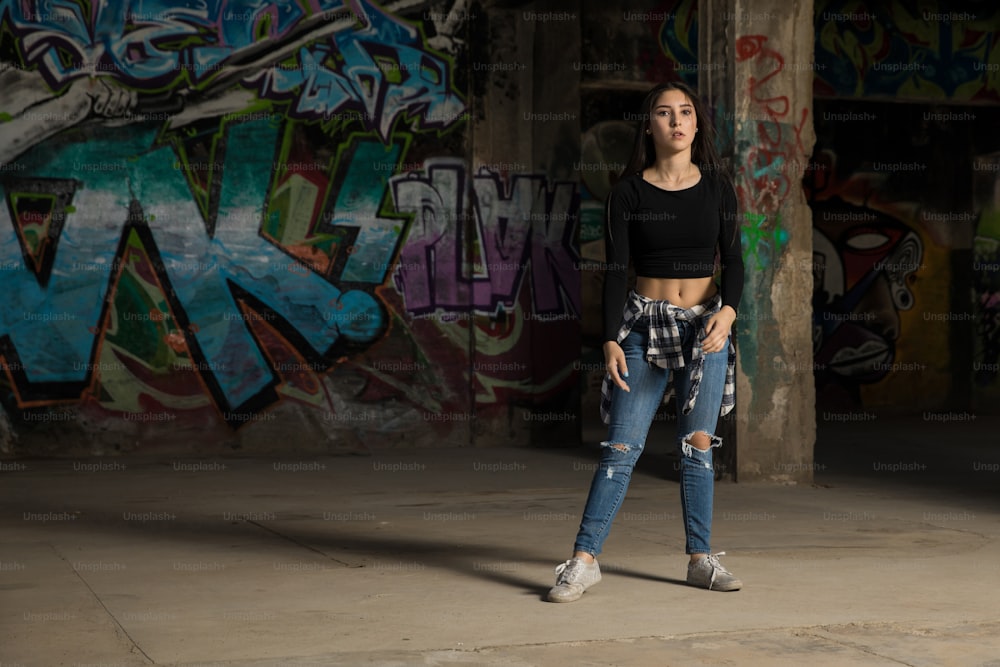 Portrait en pied d’une belle danseuse hip-hop s’apprêtant à pratiquer quelques mouvements dans un bâtiment abandonné