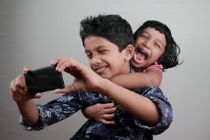 Boy and girl having fun while taking selfie with a mobile