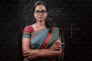 Retrato de uma professora indiana em frente a um quadro negro