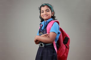 Retrato de una colegiala sonriente con uniforme y bolso
