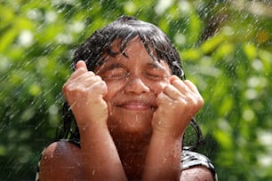 Una niña juega con agua al aire libre