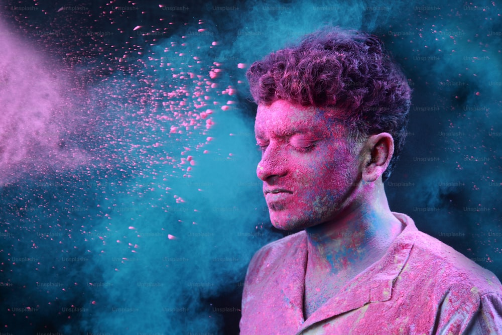 Un jeune homme maculé de couleurs joue Holi.Concept pour le festival indien Holi.