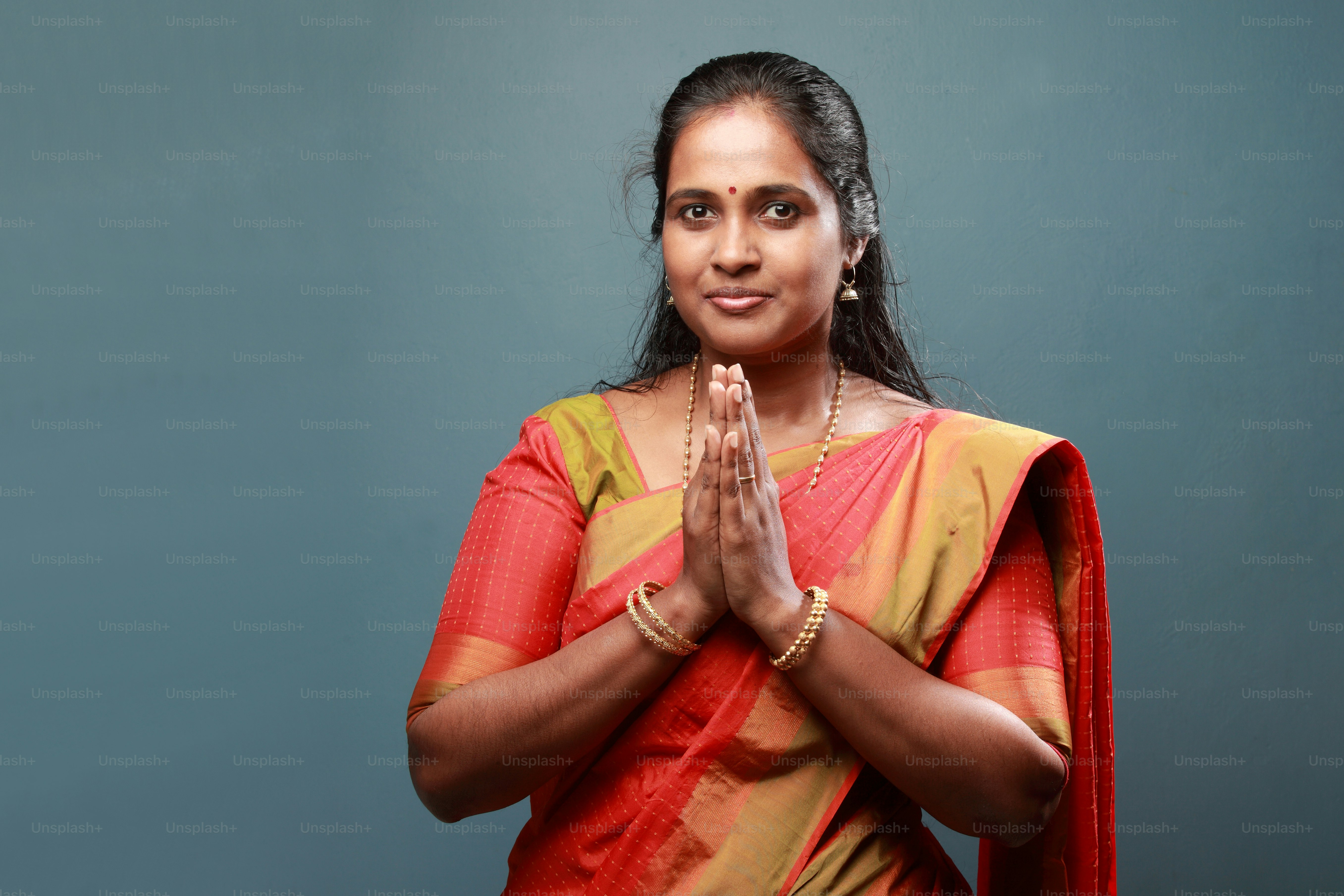 Traditionally dressed South Indian woman salutes with folded hands
