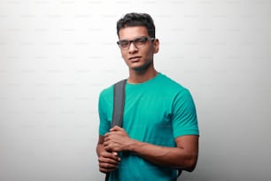 Jovem estudante feliz de origem indiana carregando bolsa de ombro