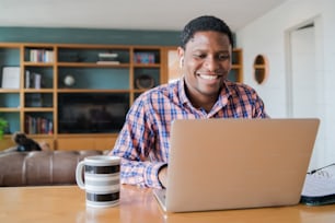 Retrato de hombre en una videollamada de trabajo con portátil desde casa. Concepto de oficina en casa. Nuevo estilo de vida normal.
