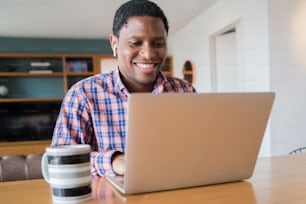自宅からノートパソコンを使った仕事のビデオ通話をする男性のポートレート。ホームオフィスのコンセプト。ニューノーマルライフスタイル。