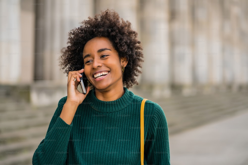 Portrait d’une femme d’affaires afro parlant au téléphone alors qu’elle se tenait dehors dans la rue. Concept commercial et urbain.
