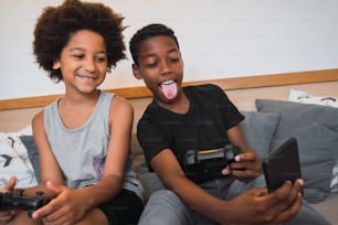 두 명의 아프리카계 미국인 형제가 집에서 휴대폰으로 셀카를 찍는 초상화. 라이프스타일과 기술 개념.