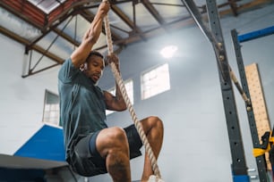 Retrato de un hombre atlético haciendo ejercicio de escalada en el gimnasio. Concepto de gimnasio, deporte y estilo de vida saludable.