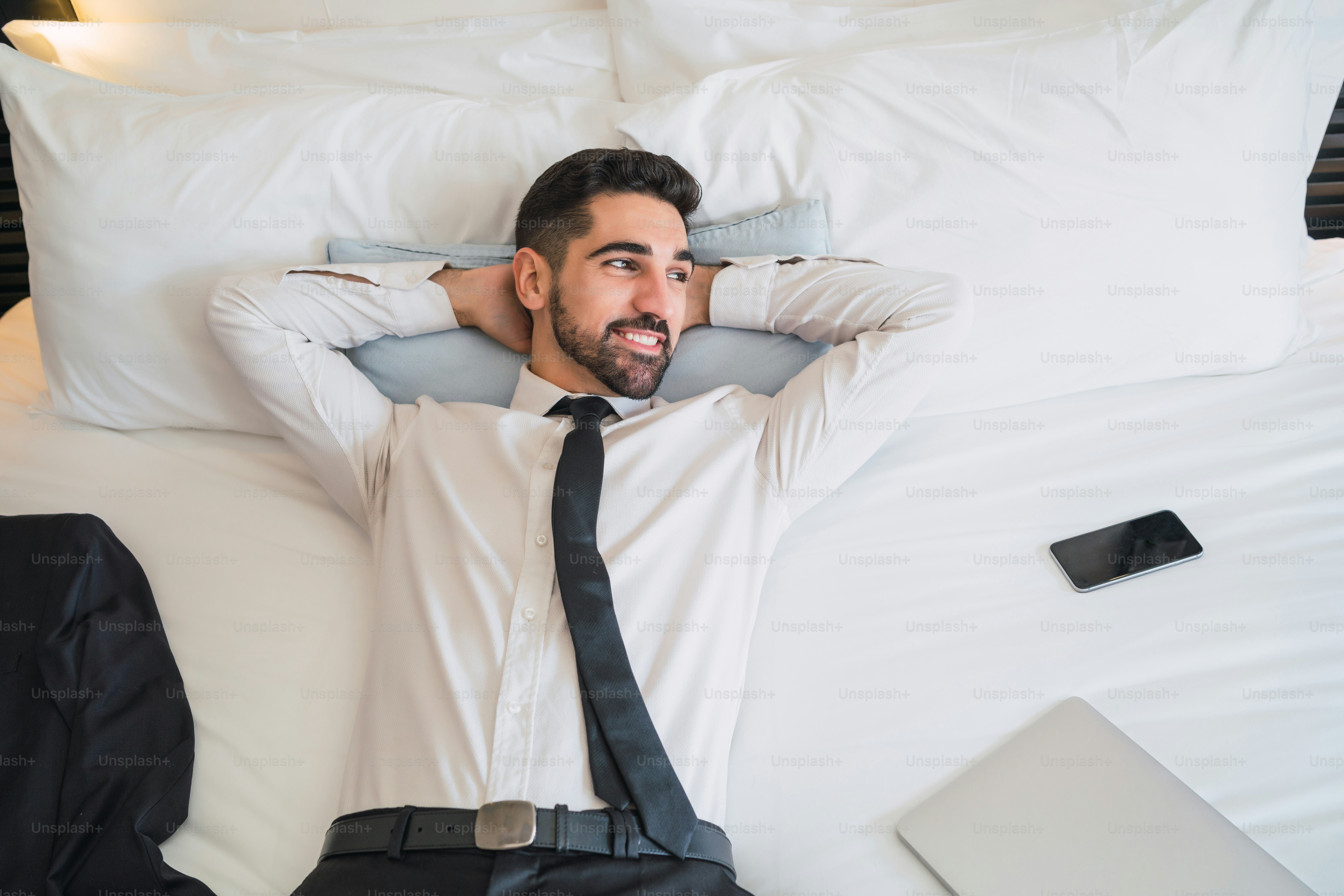 Portrait of young businessman taking a break from work and relaxing after a hard day at the hotel room. Business travel concept.