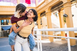 Portrait of lovely lesbian couple spending time together and having fun at the street. LGBT concept.