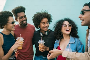 Retrato de um grupo multiétnico de amigos se divertindo juntos e desfrutando de bons momentos enquanto bebem suco de frutas frescas.