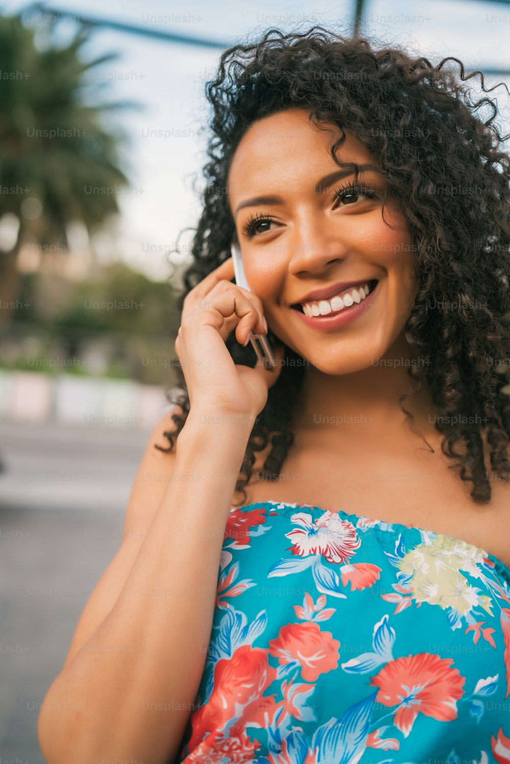 Portrait of young afro american latin woman talking on the phone outdoors in the street. Technology concept.