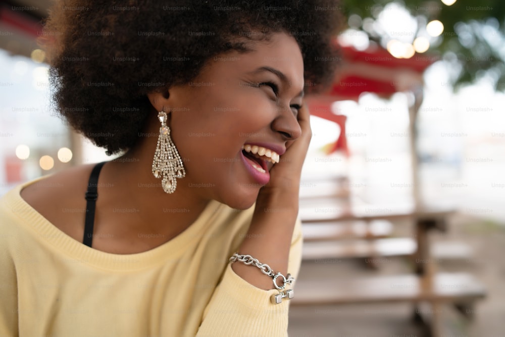 Close-up of a beautiful afro american latin woman smiling and spending nice time at the coffee shop.