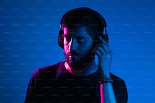 Neon light portrait of bearded man in headphones. Listening to music