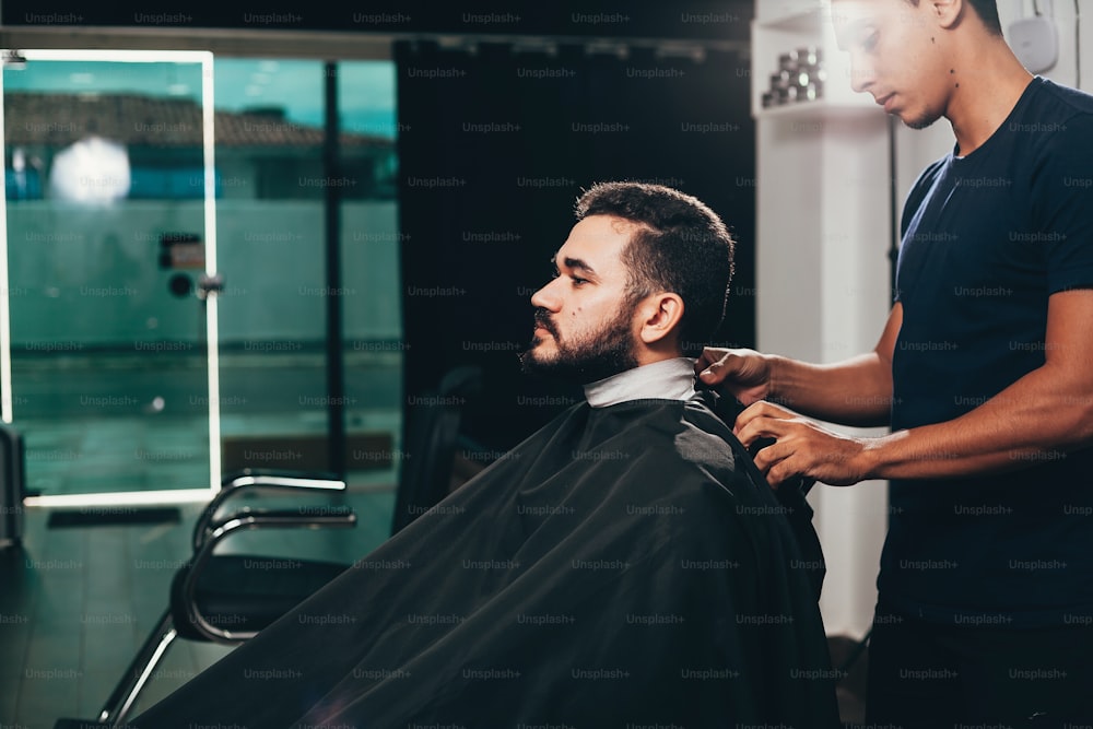 Client during beard and hair grooming in barber shop