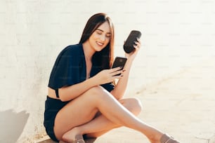 Young beautiful woman enjoying the music. Woman listening music by wireless speaker