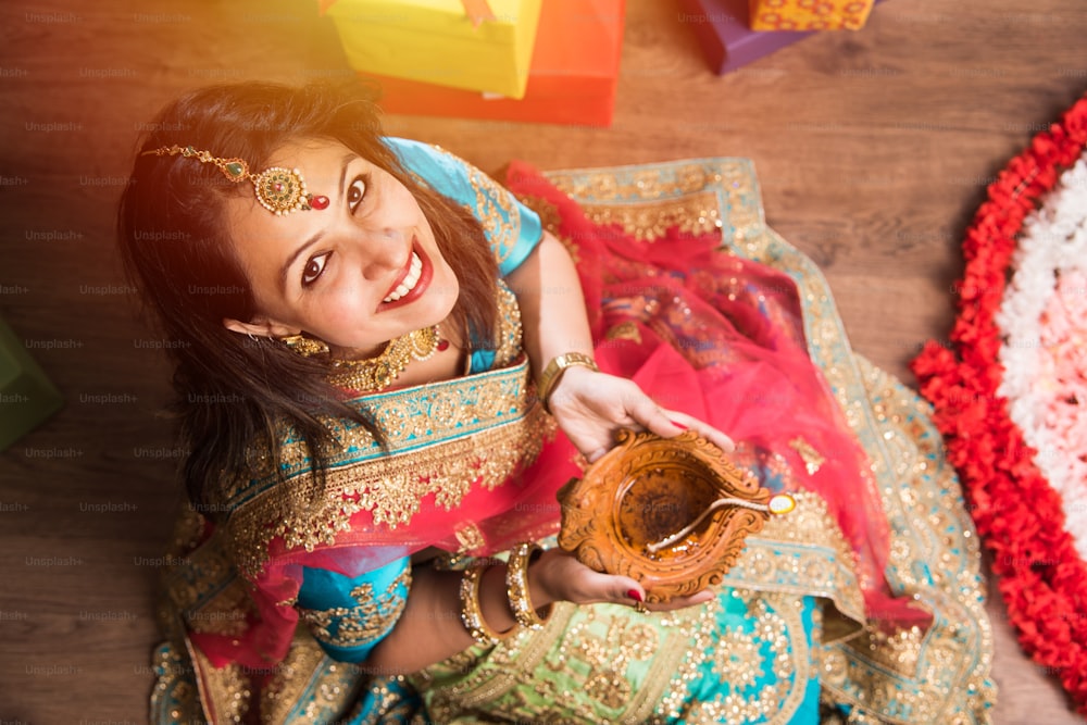 Belle fille indienne tenant Diya lors de la nuit du festival de Diwali, vue de dessus.Focus sélectif