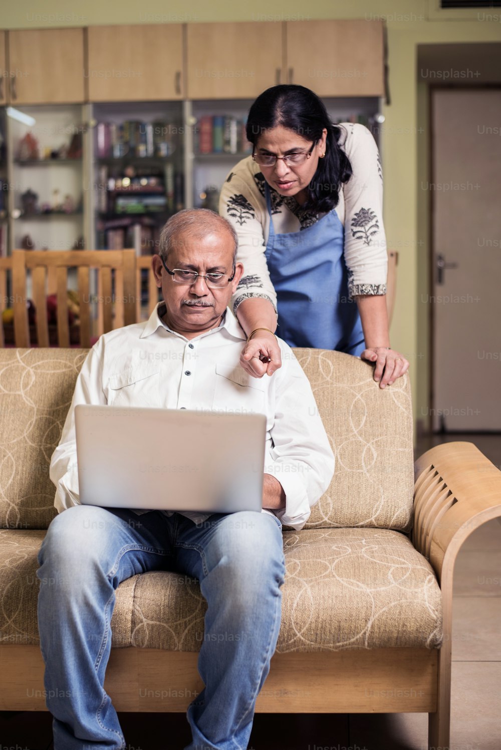 Contabilidad de parejas indias / asiáticas mayores, haciendo finanzas en el hogar y revisando facturas con computadora portátil, calculadora y dinero mientras está sentado en el jardín de su casa