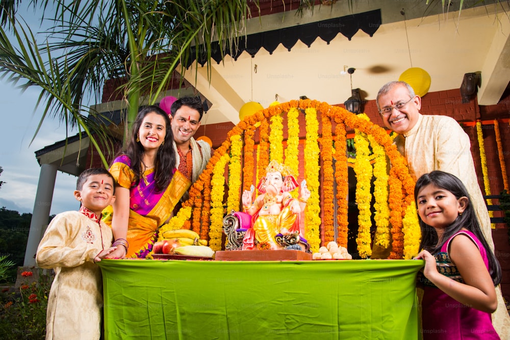 Ganesh 축제의 Lord Ganesha 우상 또는 화환 꽃으로 장식된 Palkhi의 Ganesh Chaturthi를 환영하는 쾌활한 인도 가족